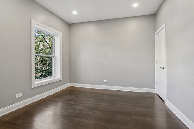 unfurnished room with dark wood-type flooring