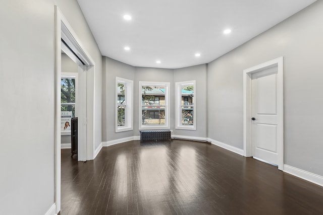 unfurnished living room with dark wood-type flooring