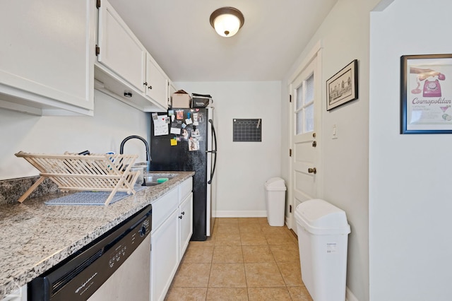 kitchen featuring light tile patterned floors, sink, appliances with stainless steel finishes, white cabinetry, and light stone counters