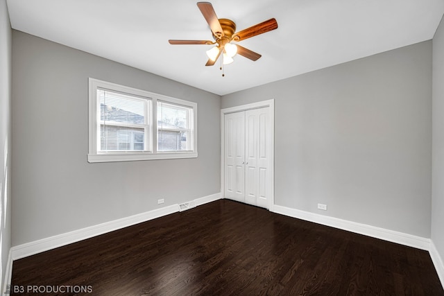 unfurnished bedroom with ceiling fan, a closet, and dark hardwood / wood-style floors