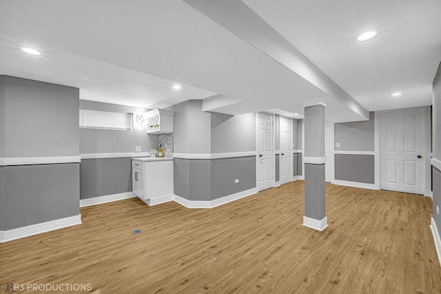 basement with light hardwood / wood-style flooring