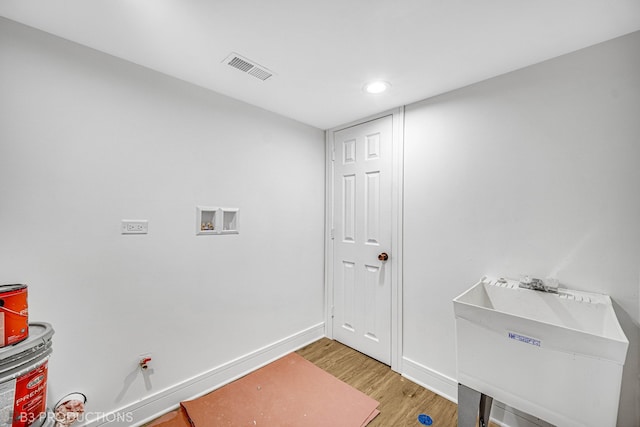 laundry area with hookup for a washing machine, hardwood / wood-style floors, and sink