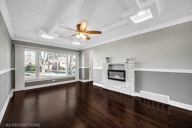 unfurnished living room featuring ceiling fan, ornamental molding, a fireplace, beam ceiling, and wood-type flooring