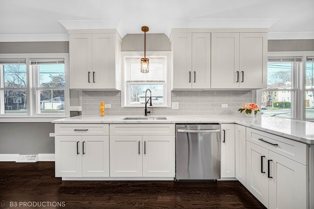 kitchen featuring light stone counters, stainless steel dishwasher, sink, pendant lighting, and dark hardwood / wood-style floors