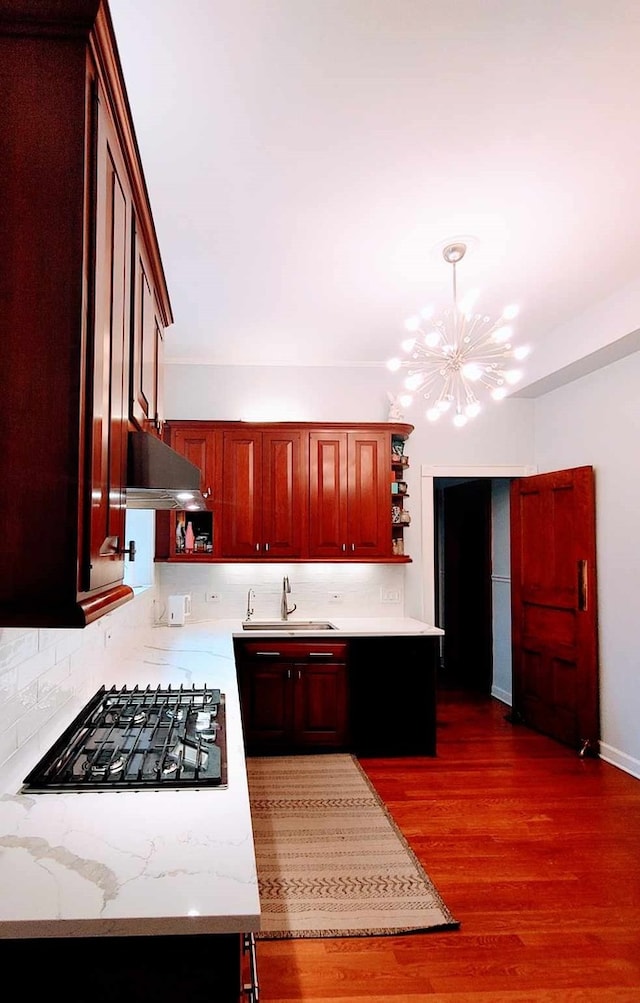 kitchen featuring extractor fan, sink, tasteful backsplash, pendant lighting, and black gas cooktop