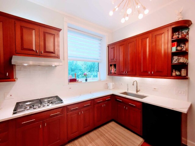 kitchen featuring sink, an inviting chandelier, backsplash, and stainless steel gas cooktop