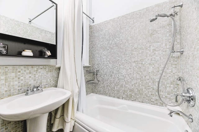 bathroom featuring tile walls, sink, shower / bath combo with shower curtain, and backsplash