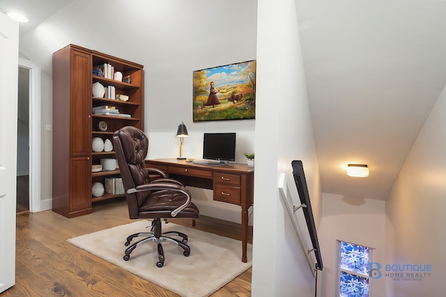 home office featuring light hardwood / wood-style floors and lofted ceiling