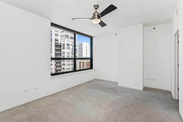 carpeted spare room featuring ceiling fan