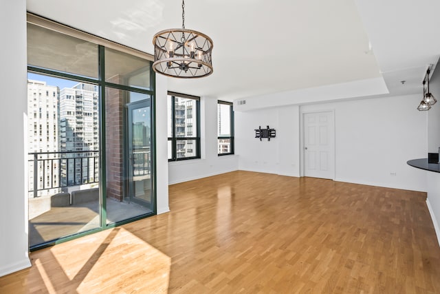 interior space with floor to ceiling windows, a chandelier, and hardwood / wood-style flooring