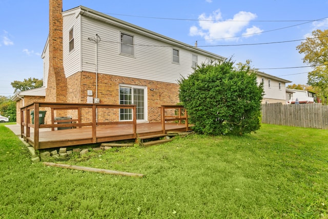 back of house with a lawn and a wooden deck