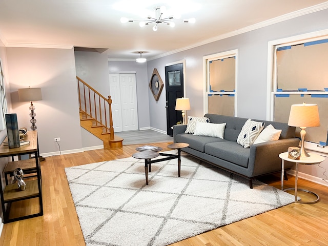 living room with ornamental molding, a notable chandelier, and hardwood / wood-style flooring