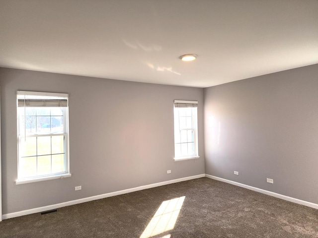 empty room with dark colored carpet