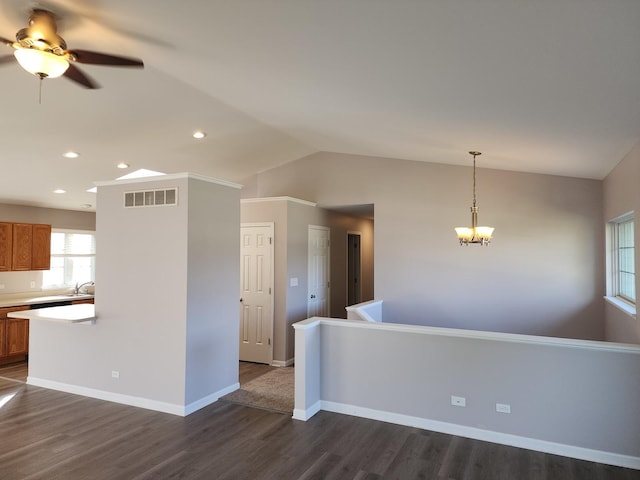 kitchen featuring ceiling fan with notable chandelier, vaulted ceiling, sink, decorative light fixtures, and dark hardwood / wood-style floors