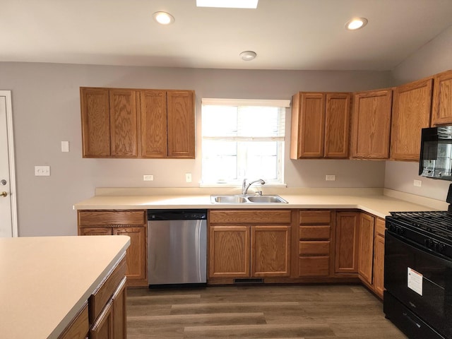 kitchen featuring dark wood-type flooring, sink, and black appliances