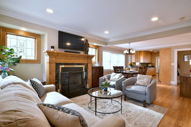 living room featuring a notable chandelier, light hardwood / wood-style floors, and ornamental molding