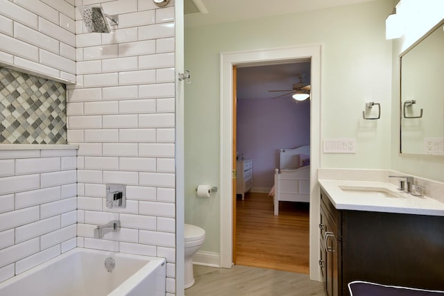 full bathroom with vanity, ceiling fan, wood-type flooring, toilet, and tiled shower / bath