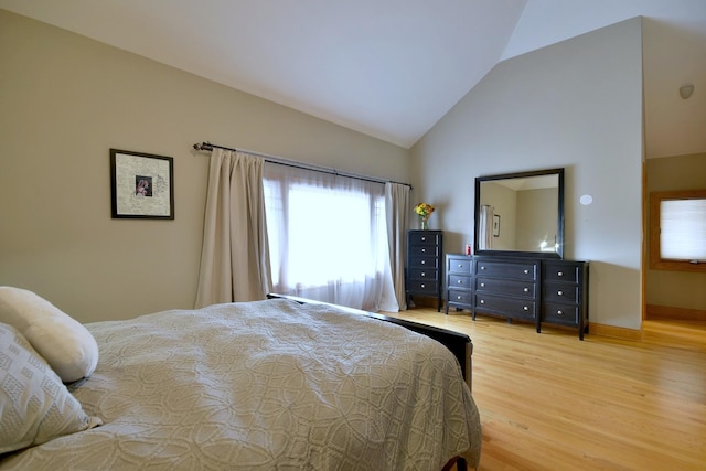 bedroom with light wood-type flooring and vaulted ceiling