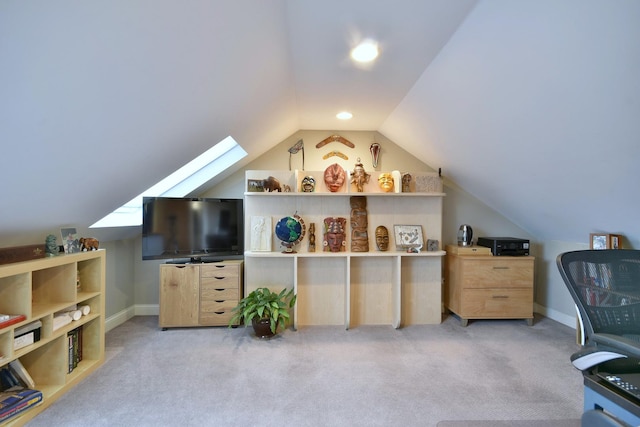 interior space featuring light colored carpet and vaulted ceiling with skylight