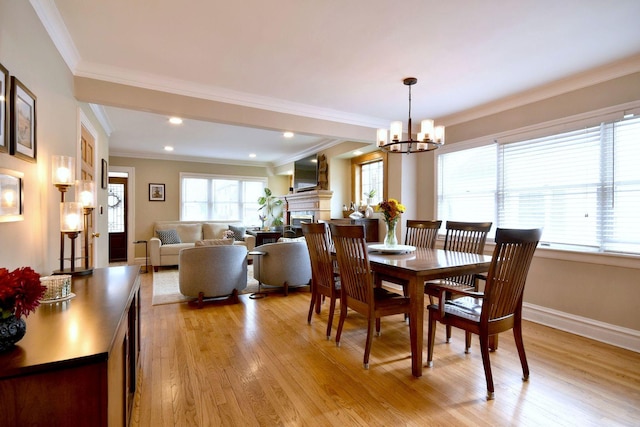 dining room featuring ornamental molding, light wood-type flooring, and a notable chandelier