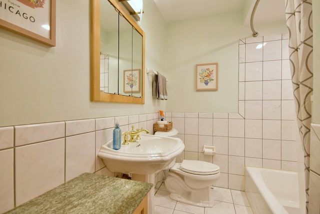 bathroom featuring tile patterned flooring, shower / bath combination with curtain, toilet, and tile walls