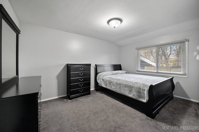 bedroom with dark carpet and vaulted ceiling