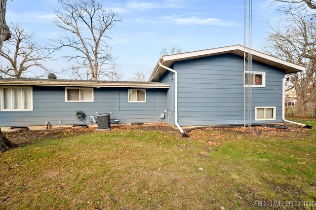 rear view of property with a yard and cooling unit