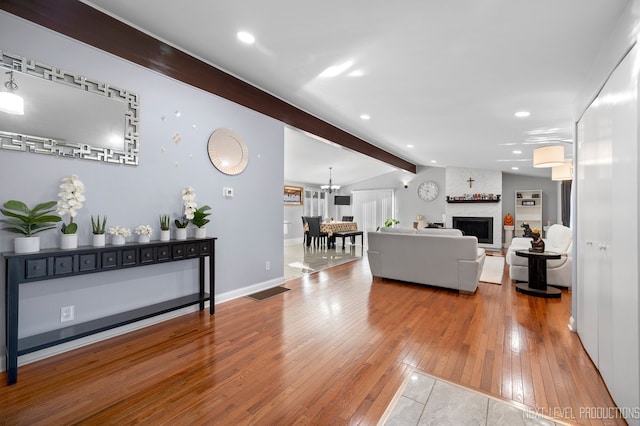 living room with hardwood / wood-style floors, lofted ceiling with beams, and a fireplace