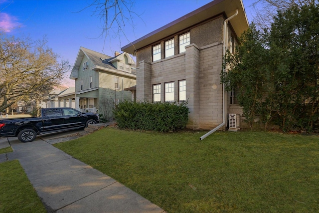 property exterior at dusk with a lawn