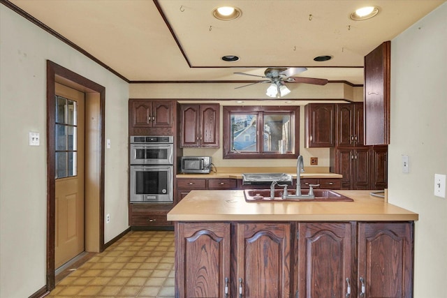 kitchen with sink, ceiling fan, kitchen peninsula, stainless steel appliances, and crown molding