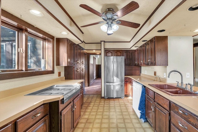 kitchen with cooktop, sink, stainless steel fridge, dishwasher, and ceiling fan