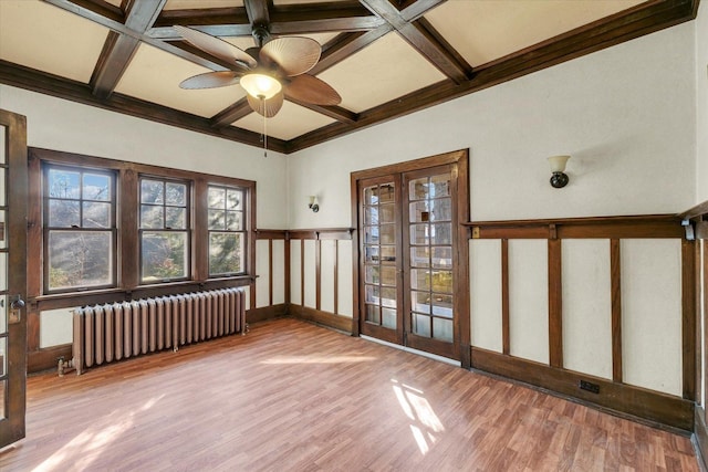 unfurnished room with hardwood / wood-style flooring, radiator heating unit, coffered ceiling, french doors, and beamed ceiling