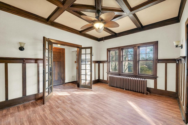 interior space with coffered ceiling, hardwood / wood-style flooring, radiator heating unit, and french doors