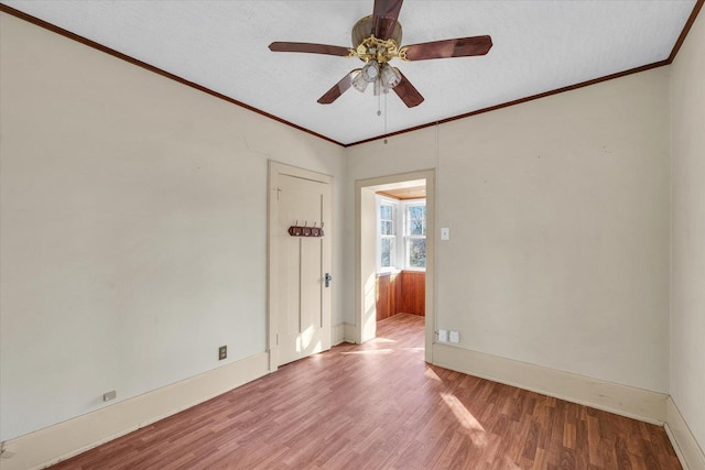 empty room with wood-type flooring, ornamental molding, ceiling fan, and a textured ceiling