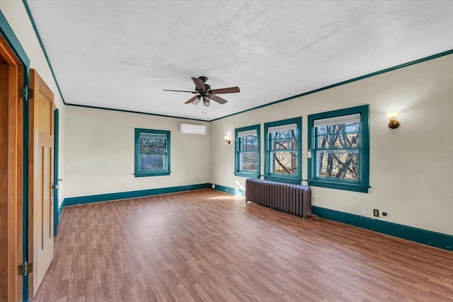 unfurnished room featuring crown molding, wood-type flooring, a textured ceiling, radiator heating unit, and ceiling fan