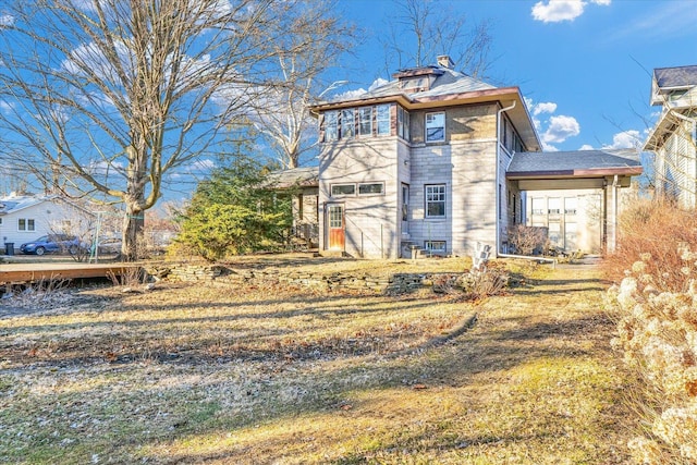 rear view of house featuring a yard