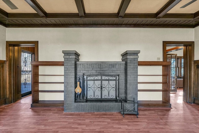 room details featuring a brick fireplace, beam ceiling, and wood-type flooring