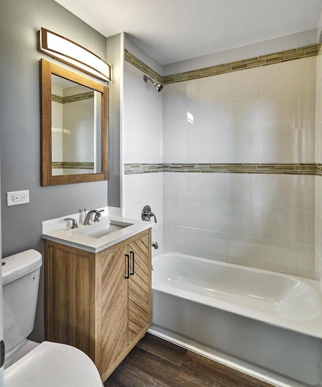 full bathroom with hardwood / wood-style flooring, vanity, toilet, and tiled shower / bath