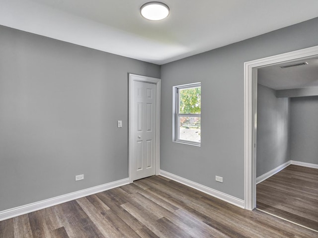 unfurnished room with dark wood-type flooring