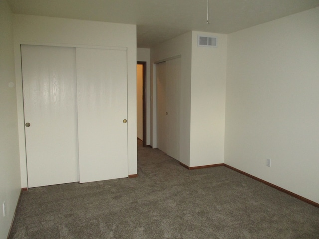 unfurnished bedroom with dark carpet