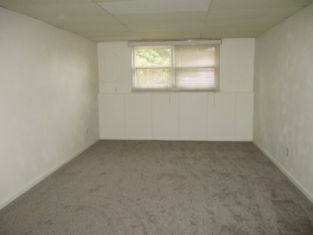 empty room with a drop ceiling and carpet