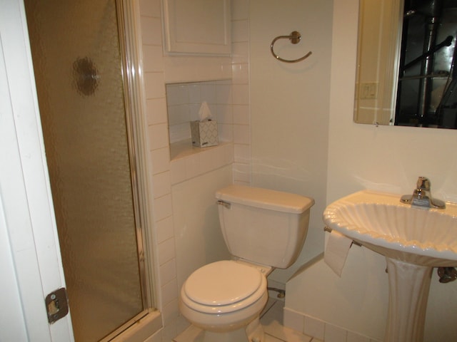 bathroom with tile patterned flooring, a shower with shower door, and toilet