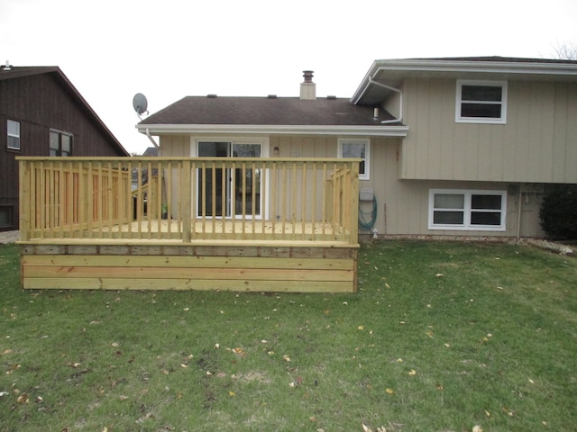 rear view of house featuring a lawn and a wooden deck