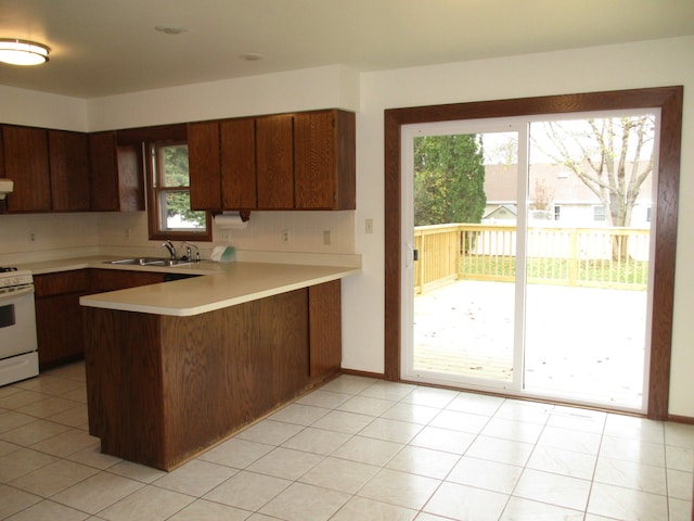 kitchen with kitchen peninsula, plenty of natural light, and sink