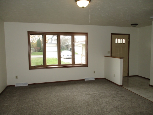 unfurnished living room with carpet floors and a textured ceiling