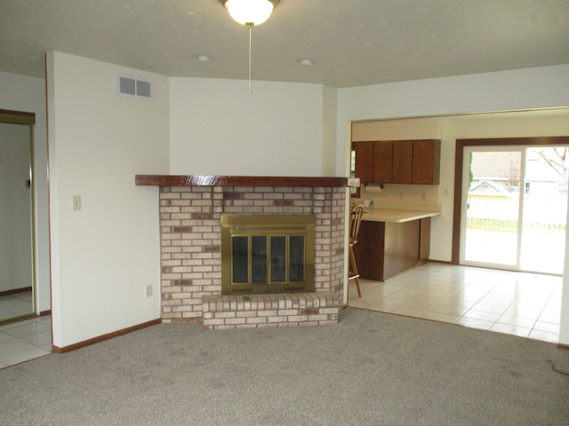 unfurnished living room with a fireplace, a textured ceiling, and light colored carpet