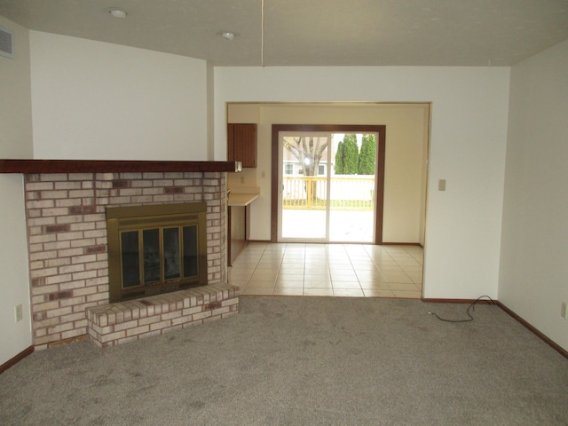 unfurnished living room featuring light colored carpet and a brick fireplace