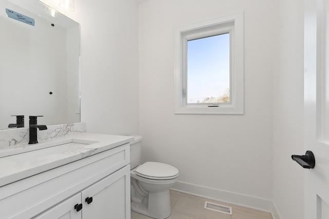 bathroom featuring tile patterned floors, vanity, and toilet