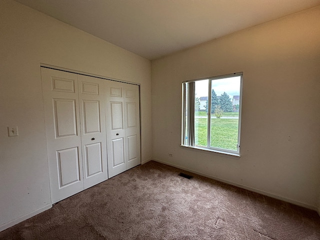 unfurnished bedroom featuring carpet flooring and a closet