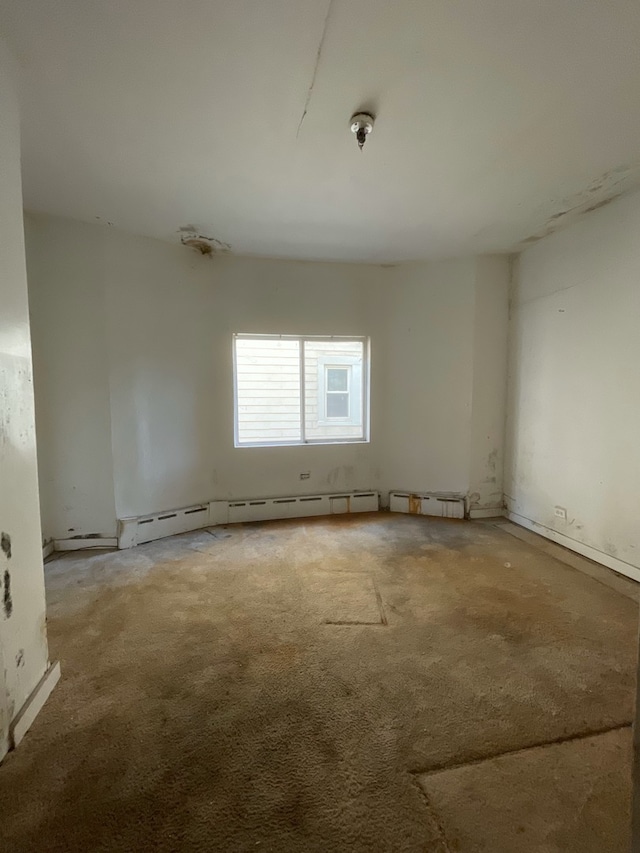 empty room featuring carpet floors and a baseboard radiator